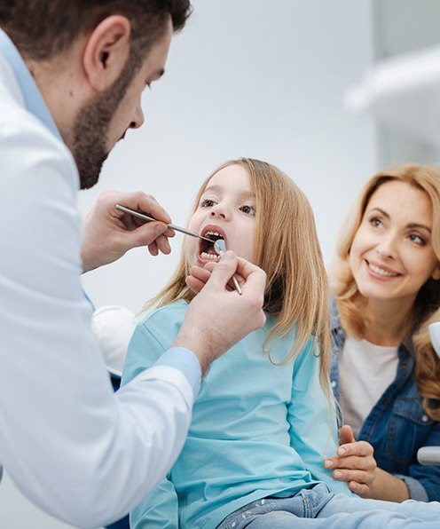 Child flossing teeth after pediatric dentistry checkup and teeth cleaning visit