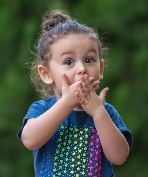 Little girl covering her mouth before pediatric emergency dentistry