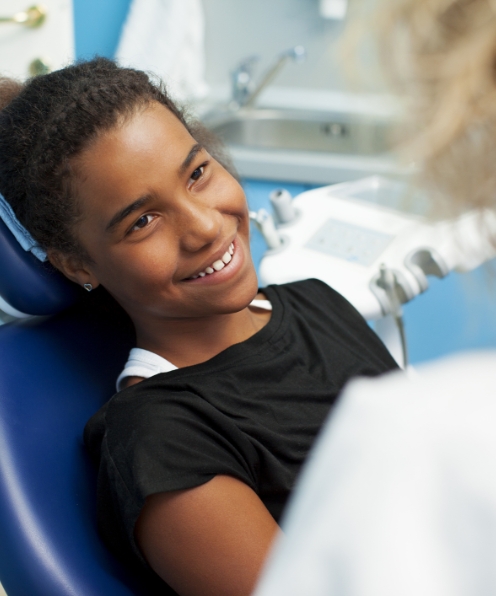 Child smiling during dental checkup to prevent dental emergencies
