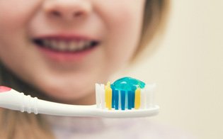 : Close-up of a child holding a toothbrush