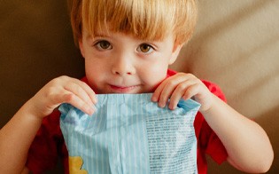 Close-up of child holding a package of cookies