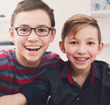 Two preteen boys receiving treatment with orthodontics and space maintainers