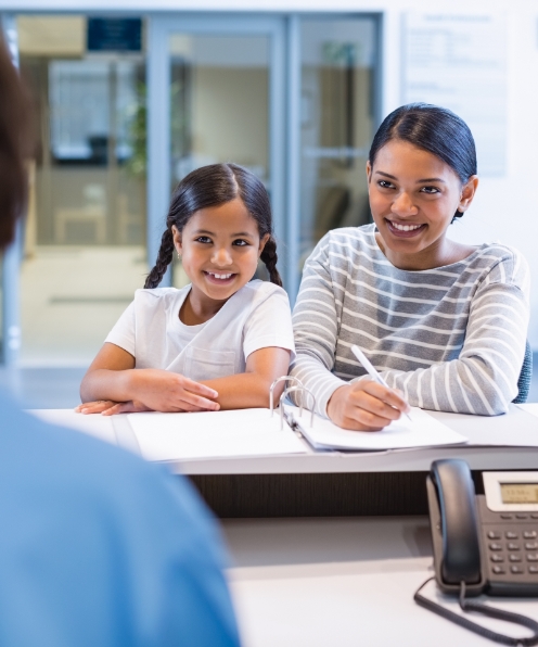 Mother and daughter filling out dental insurance forms