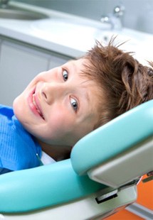child giving thumbs up while in dental chair