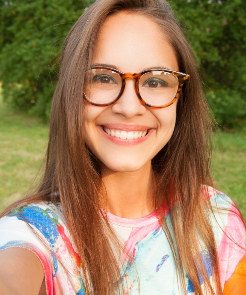 Young woman smiling after esthetic anterior dental restorations