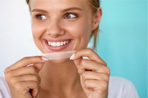 young woman with whitening strip 