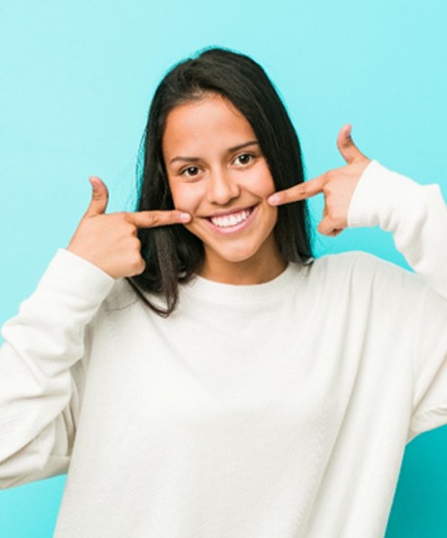 young girl pointing to white smile