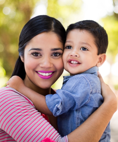 Mother holding young child after dentistry for toddlers visit