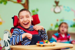 Child with intellectual or physical disabilities smiling and laughing
